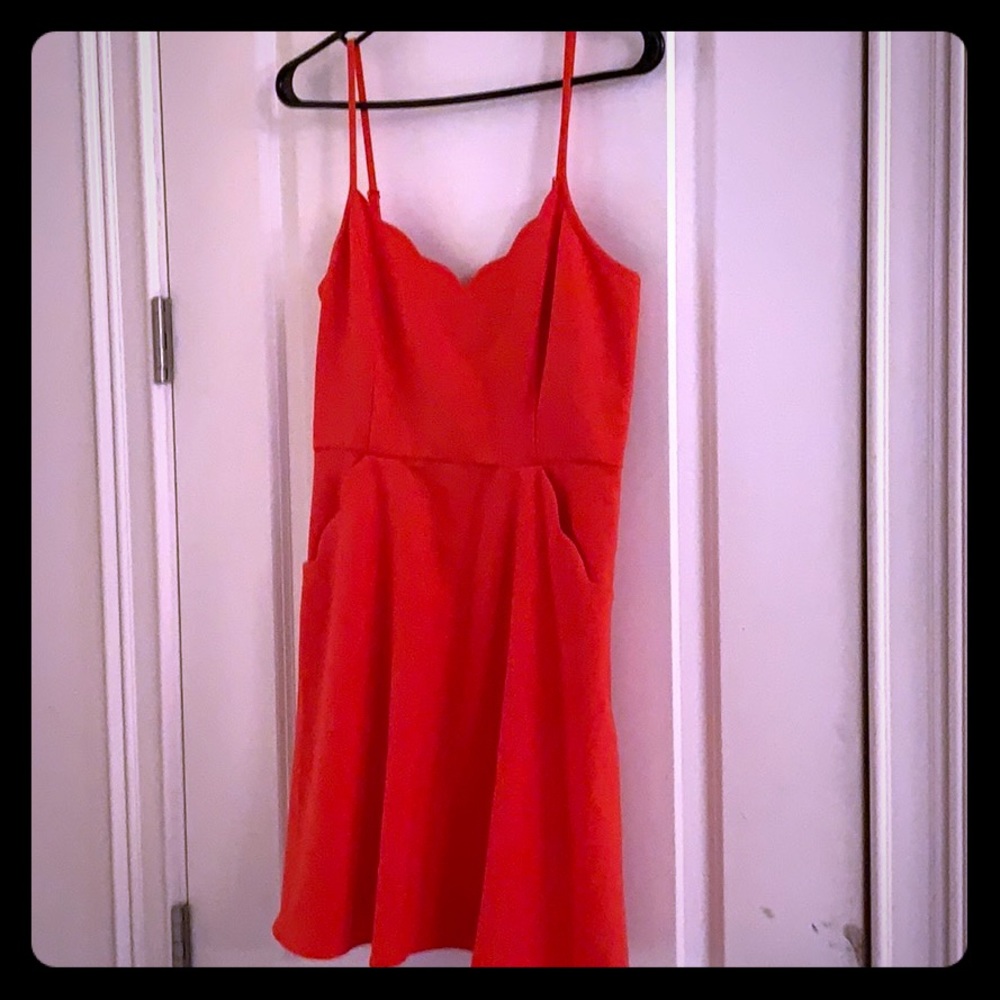 Orange Red with a scallop hem and pockets.